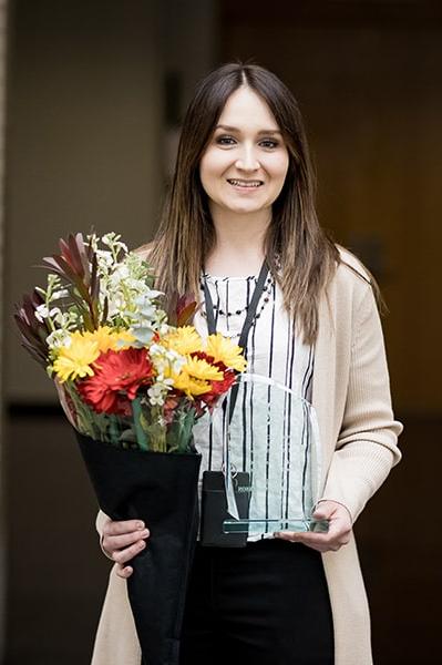 Ashley Christopherson poses with flowers and her award.